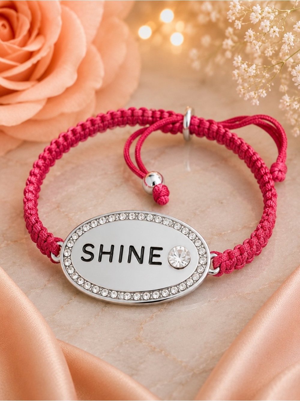 Fuchsia corded bracelet with silver bar that says Shine. Has crystal accents